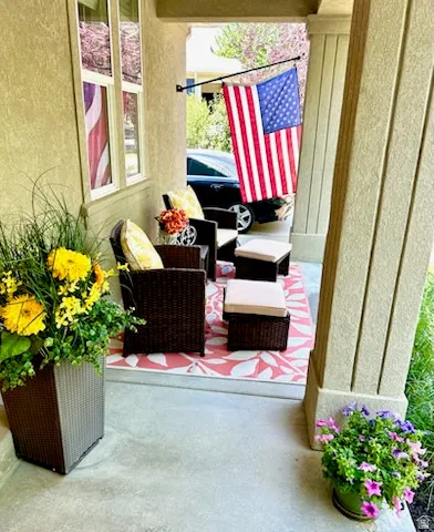 Covered front porch featuring stucco exterior, columned entry, and concrete flooring