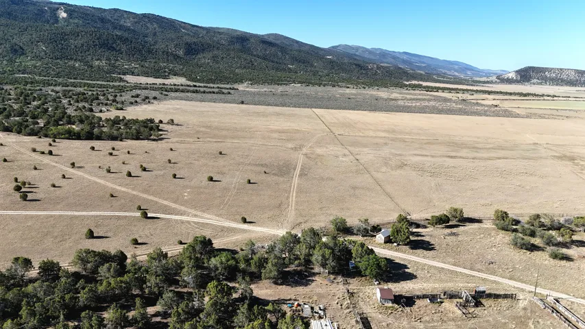 Expansive land offering diverse topography, mature trees, and mountainous backdrops