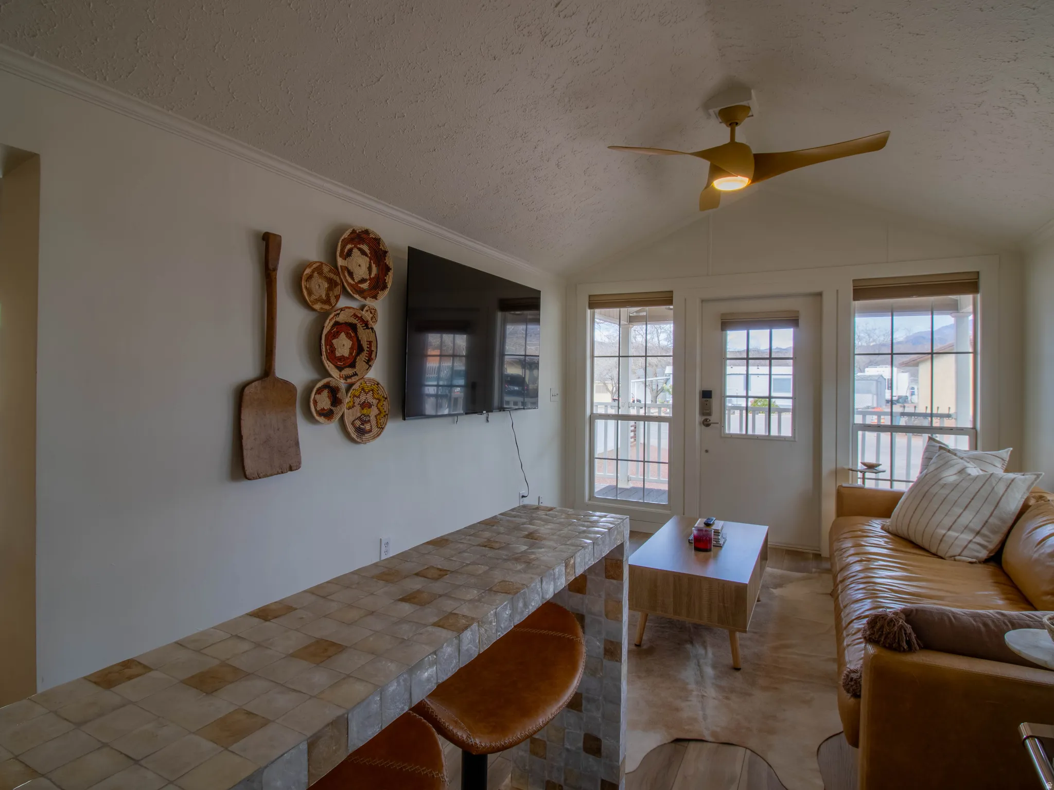 Vaulted ceiling living space with a contemporary ceiling fan and light fixture