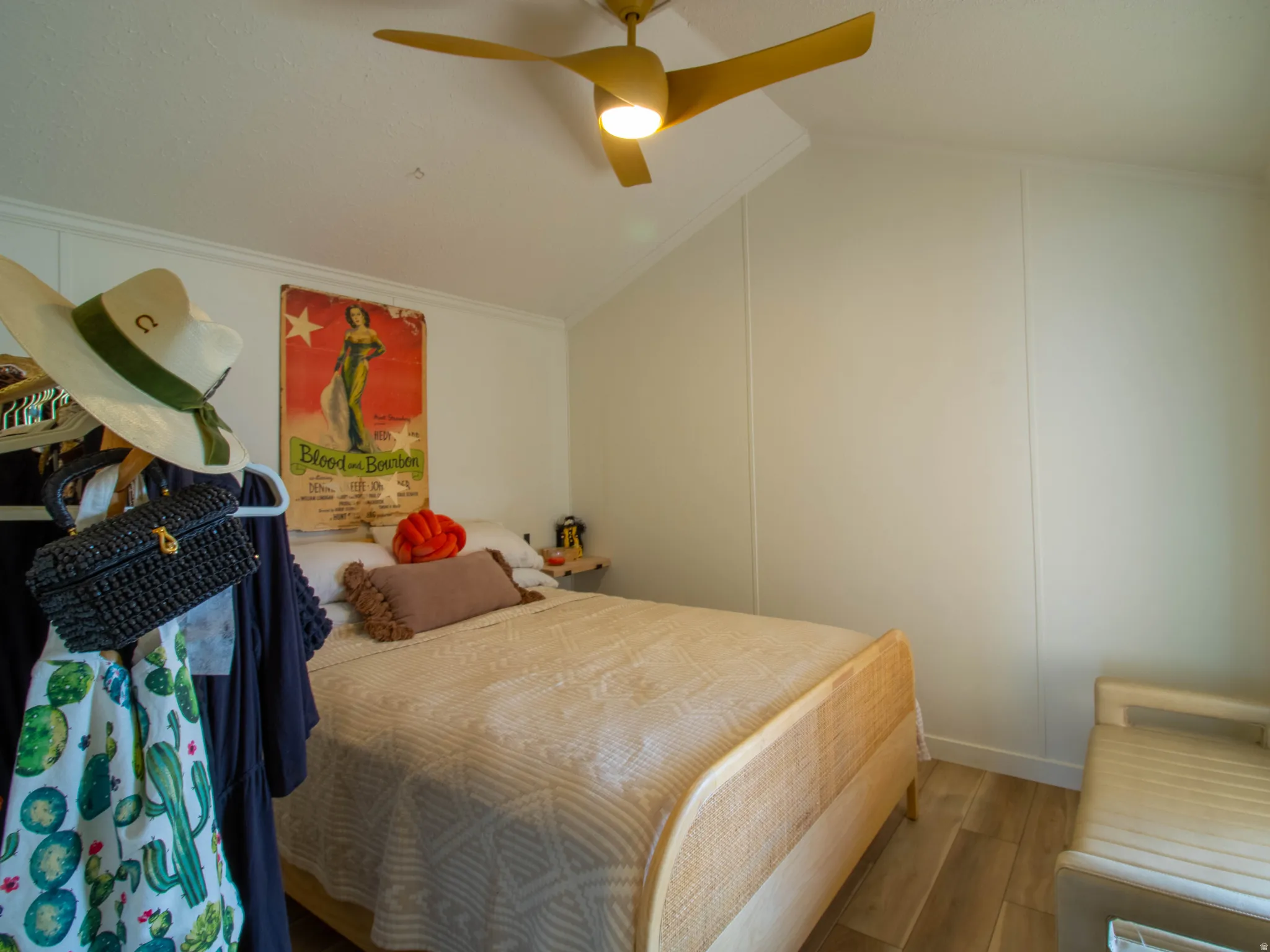 Room featuring wood-finish flooring, a sloped ceiling, and a ceiling fan with integrated lighting