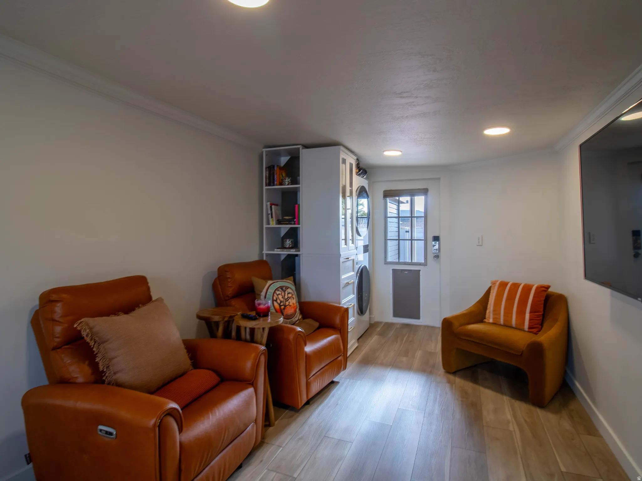 Versatile space with wood-finish flooring, recessed lighting, and crown molding
