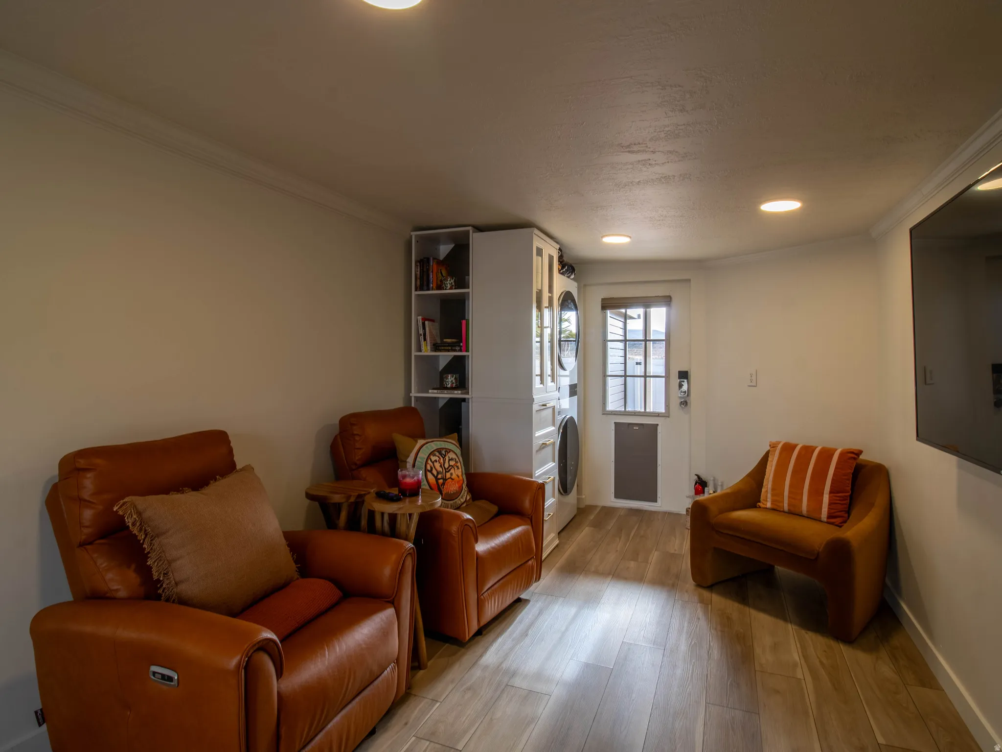 Recessed lighting illuminates a space featuring wood-finish flooring