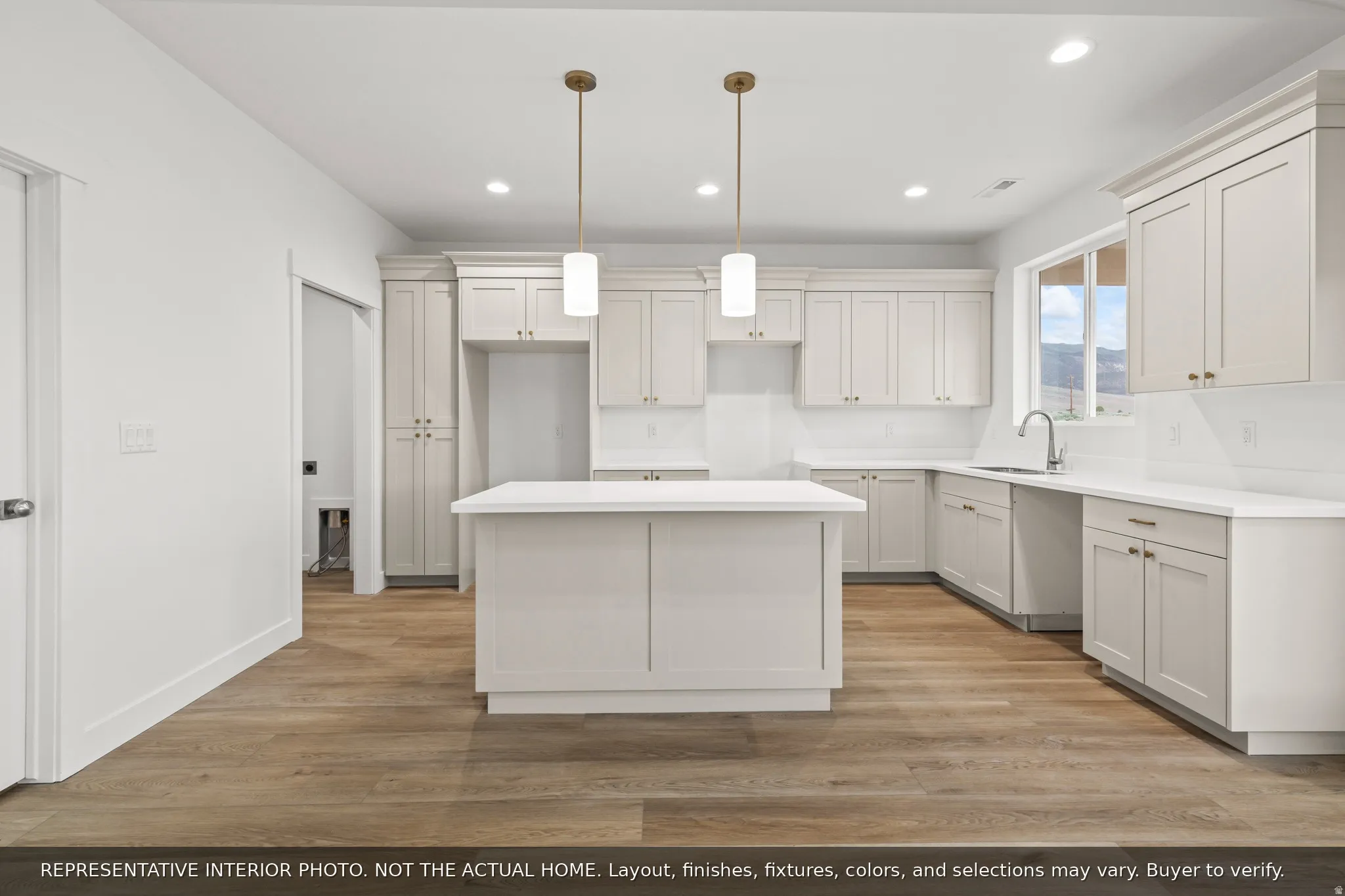 Kitchen featuring a central island, shaker-style cabinetry, white countertops, and wood-finish flooring