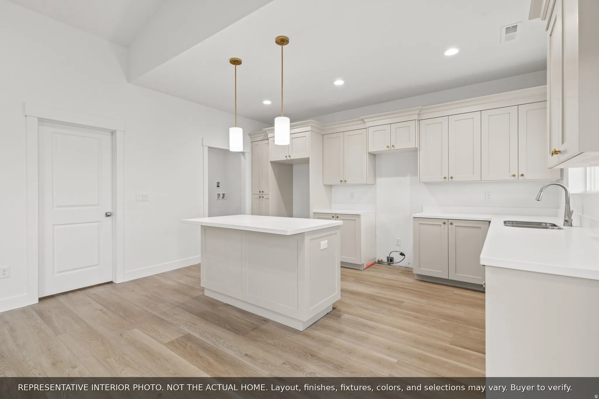 Kitchen featuring a central island with countertop, ample cabinetry, wood-finish flooring, recessed lighting, and pendant lights