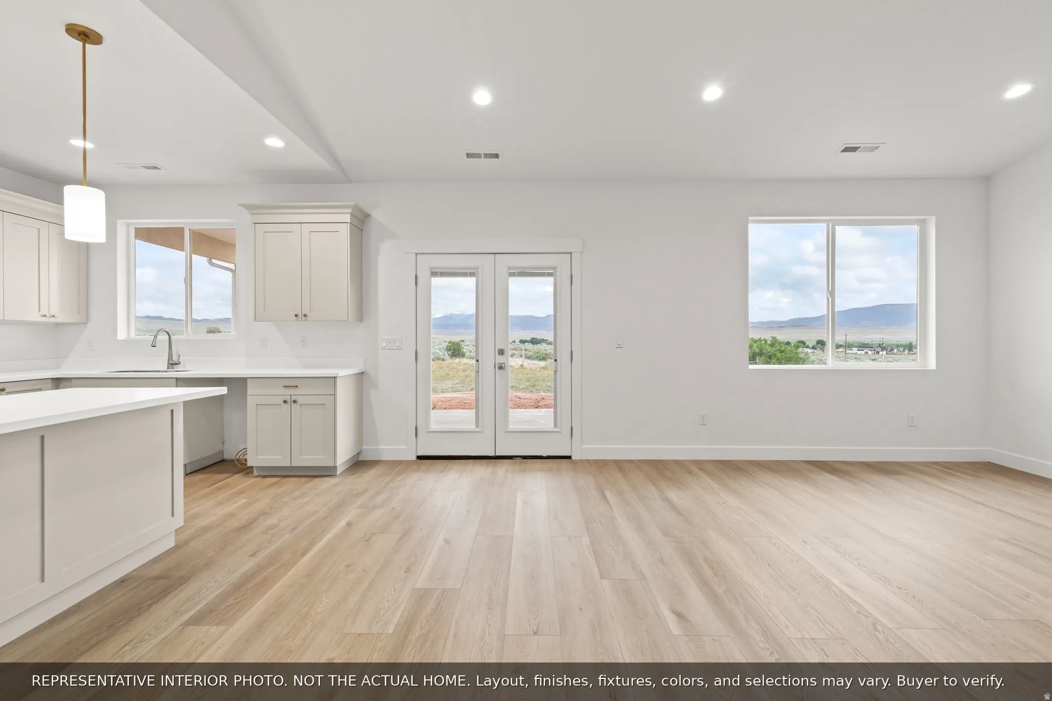 Open-concept living space featuring wood-finish flooring, recessed lighting, and a neutral color palette