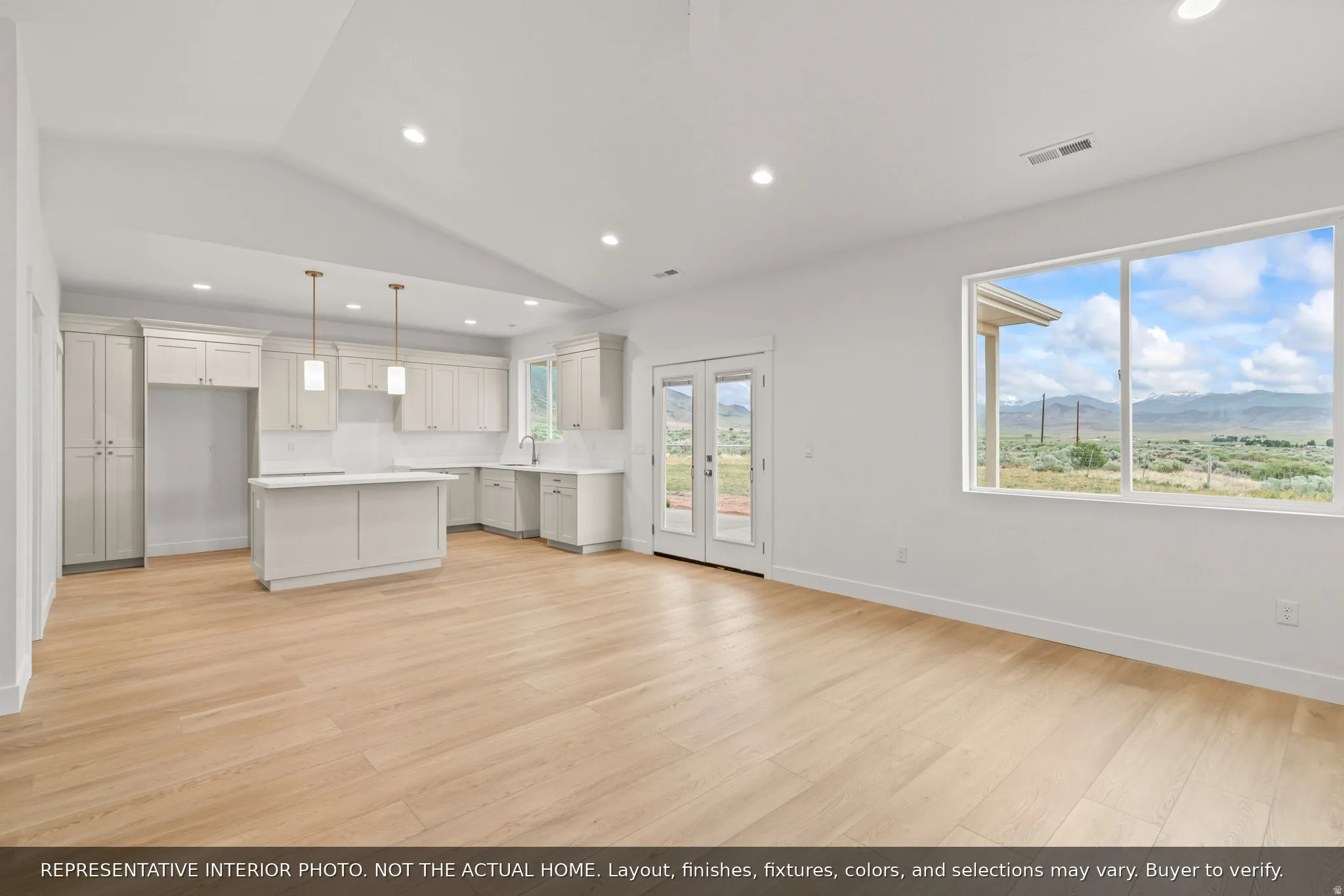 Open-concept living space with light wood-finish flooring, recessed lighting, and a vaulted ceiling