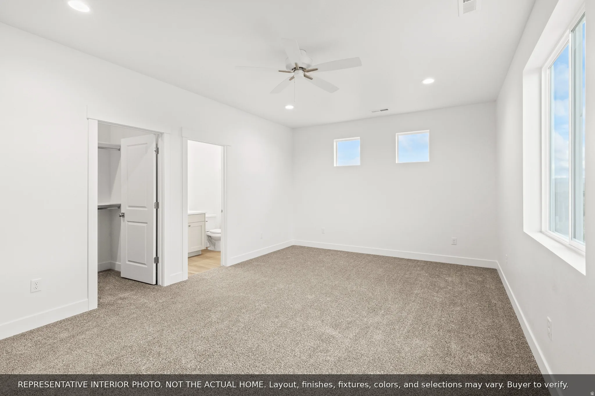 Spacious room with plush carpeting, recessed lighting, and a ceiling fan