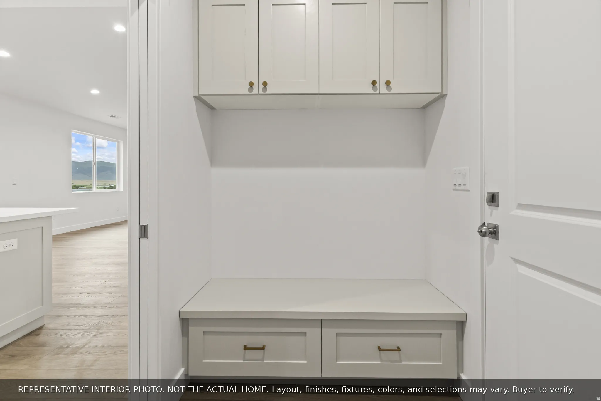 Built-in mudroom bench with storage drawers and overhead cabinetry