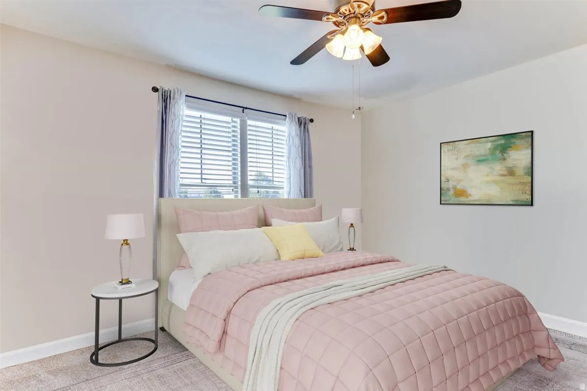 Comfortable bedroom featuring a ceiling fan with integrated lighting, window blinds, and neutral wall tones