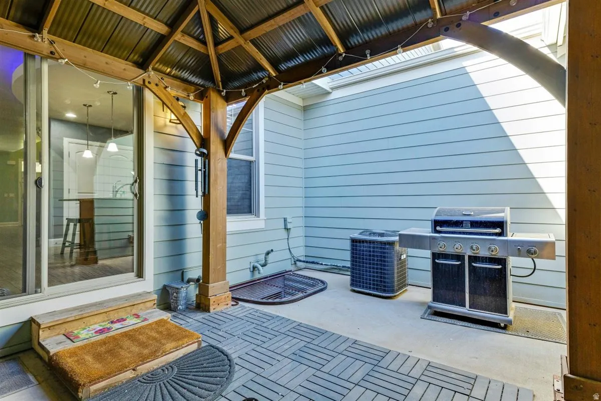 Covered patio with a wood-framed gazebo featuring a corrugated metal roof