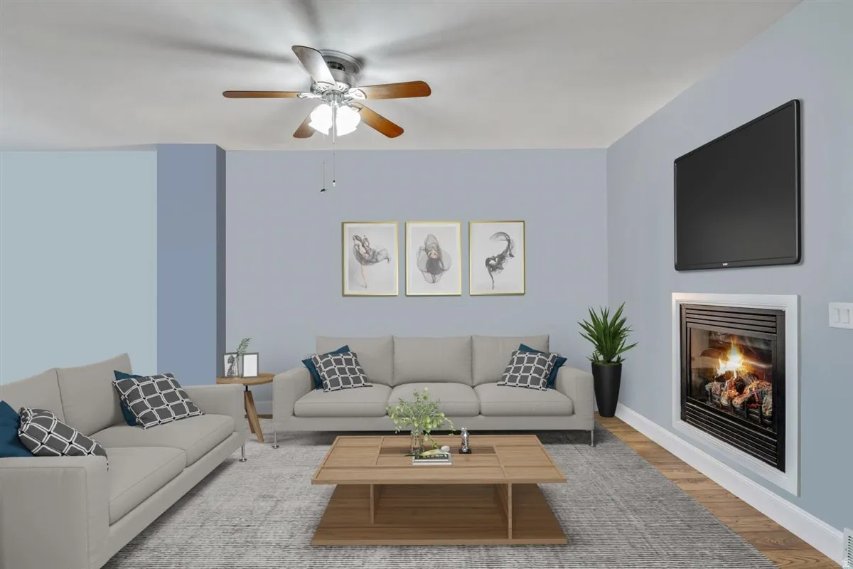 Living space featuring a built-in fireplace, wall-mounted television, and wood-finish flooring