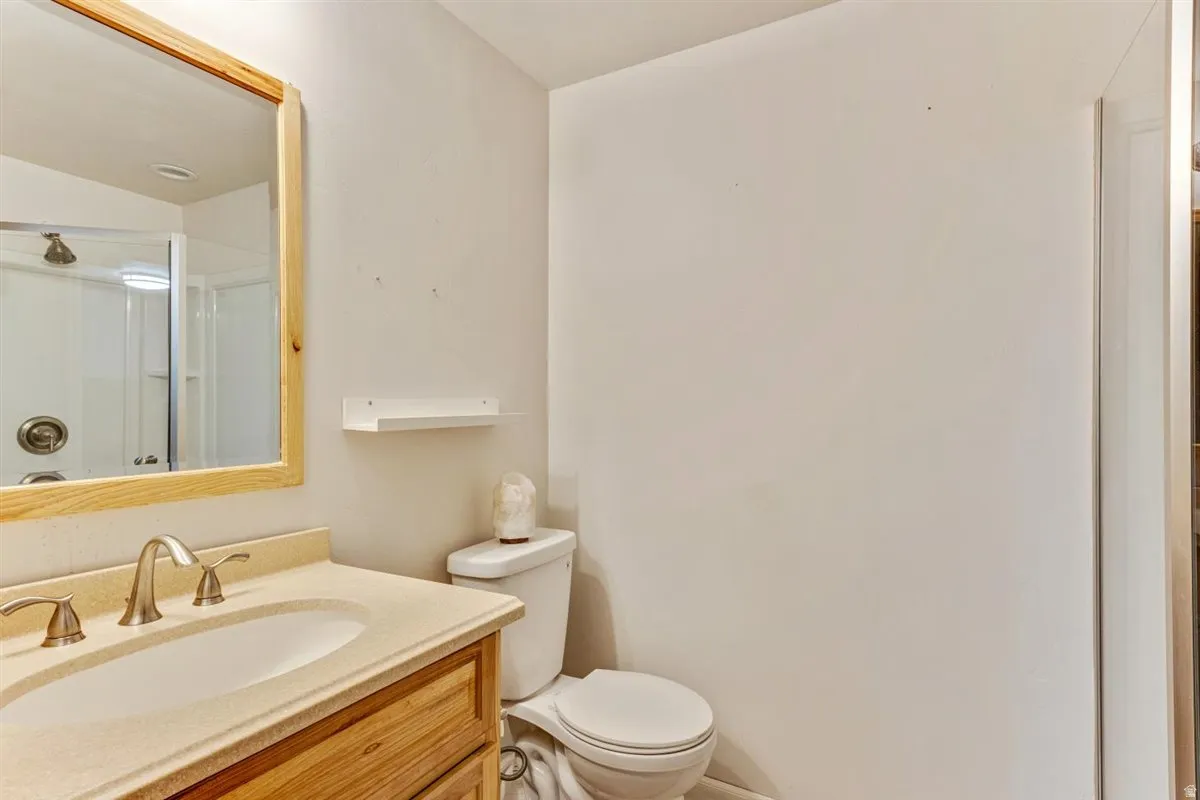 Bathroom vanity with an integrated sink, brushed nickel faucet, and natural wood cabinetry