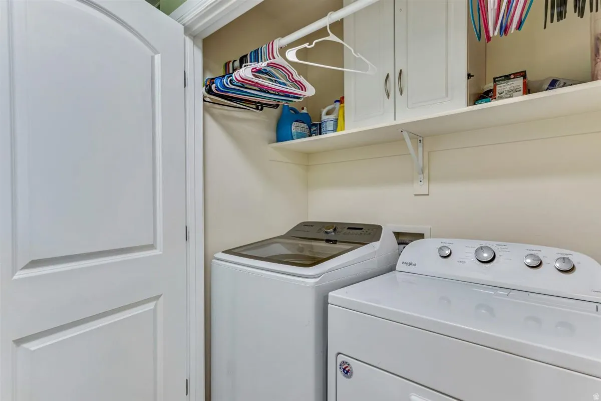 Utility space featuring a built-in shelf, white cabinetry with silver hardware, and an integrated clothing rod