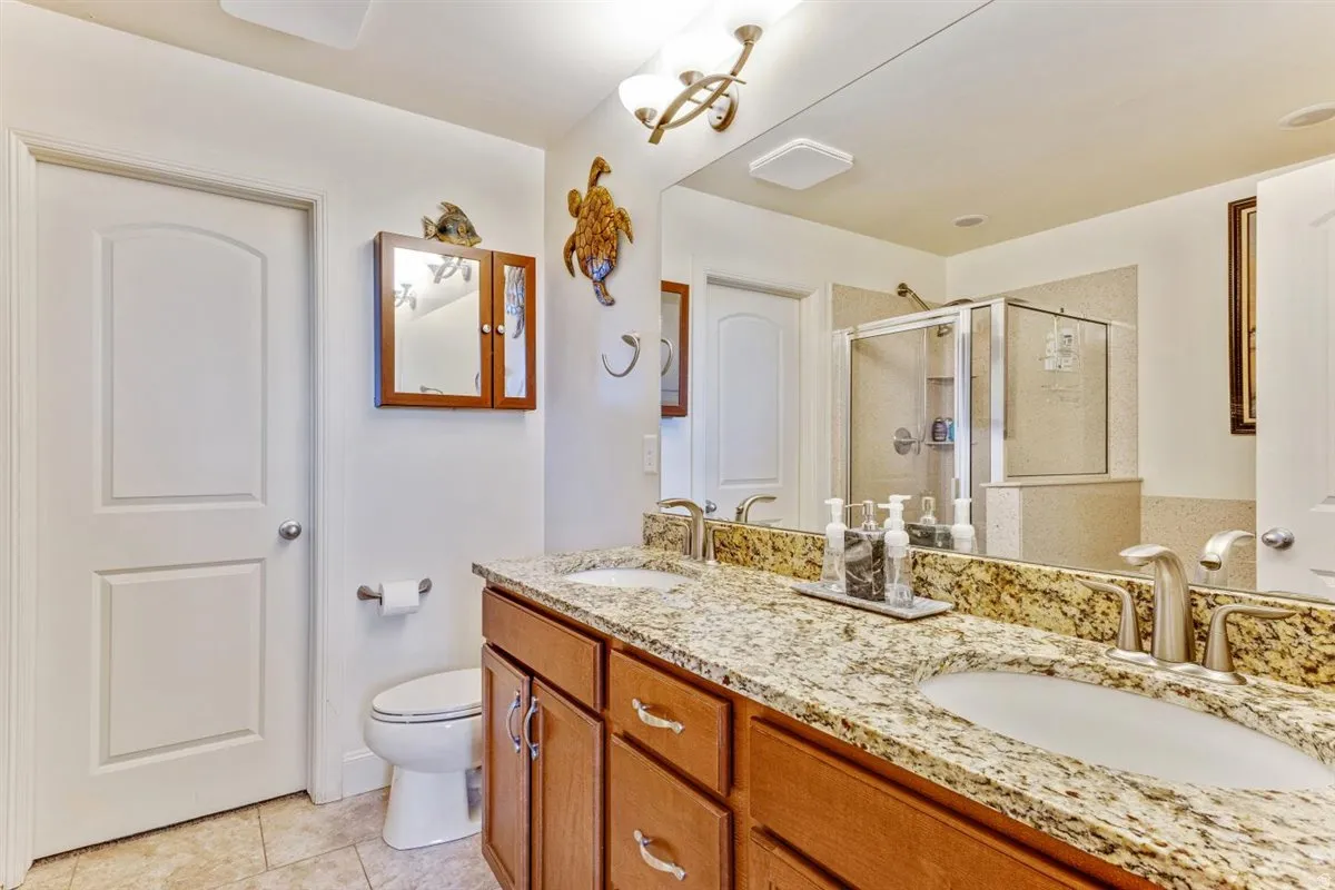 Double vanity with light-toned stone countertops and undermount sinks