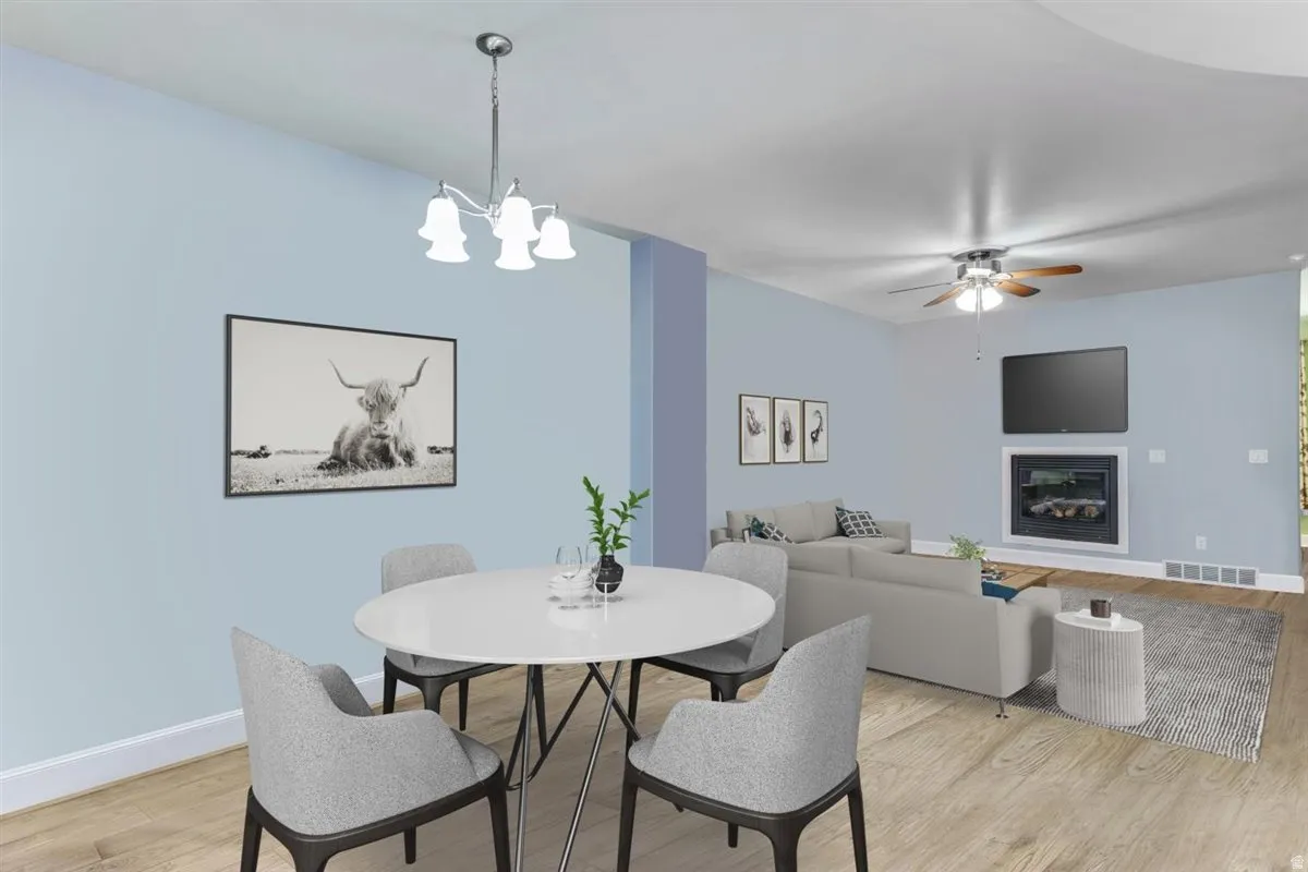 Open-concept living space featuring wood-finish flooring, a contemporary ceiling fan, and an electric fireplace