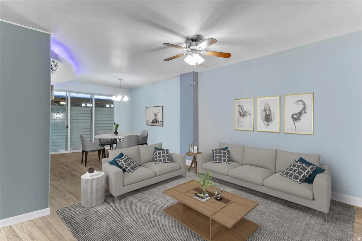 Open concept living area with light blue walls, wood-finish flooring, recessed lighting, and a ceiling fan