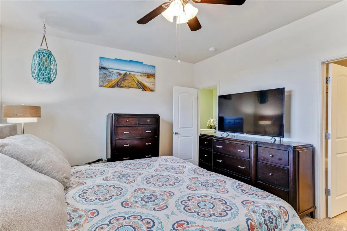 Bedroom featuring a ceiling fan with integrated lighting, neutral wall paint, and carpet flooring