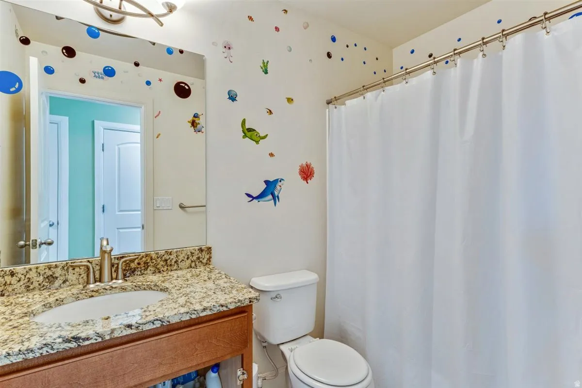 Bathroom featuring a vanity with granite countertop and undermount sink