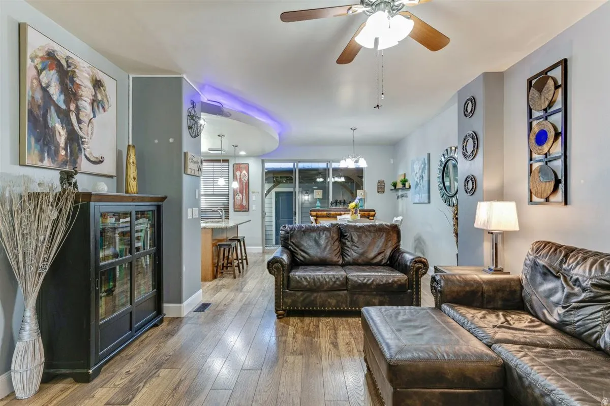Open-concept living area with wood-finish flooring, a ceiling fan, and recessed lighting
