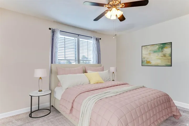 Comfortable bedroom featuring a ceiling fan with integrated lighting, window blinds, and neutral wall tones