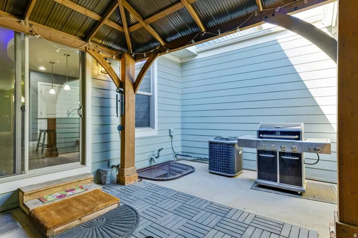 Covered patio with a wood-framed gazebo featuring a corrugated metal roof