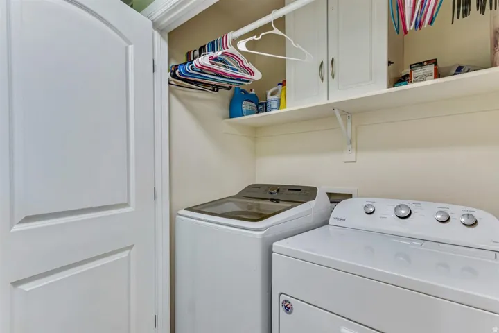 Utility space featuring a built-in shelf, white cabinetry with silver hardware, and an integrated clothing rod