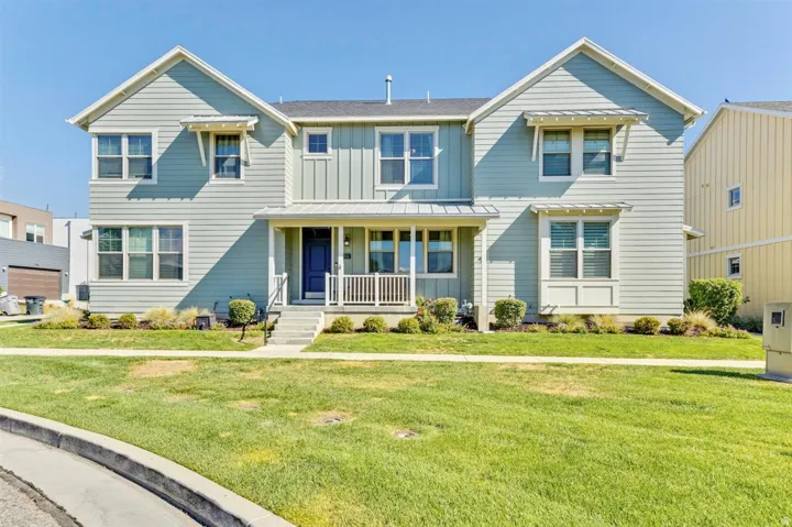 Two-story residence featuring light blue siding with white trim accents and architectural awnings
