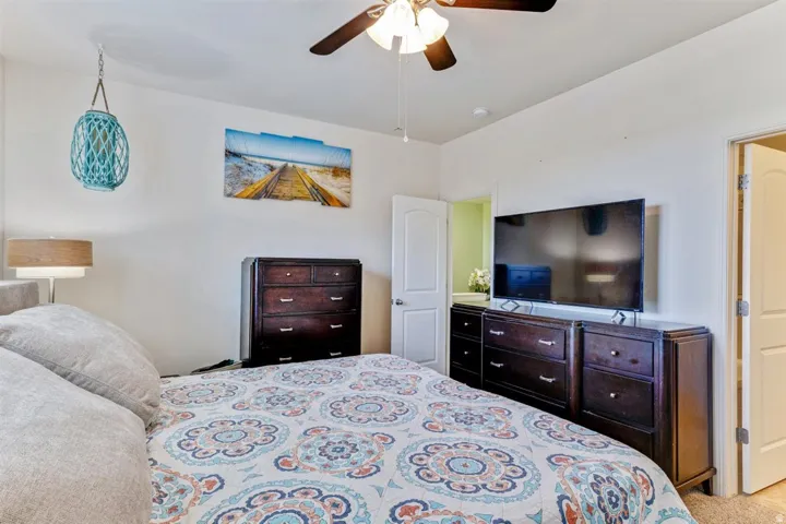 Bedroom featuring a ceiling fan with integrated lighting, neutral wall paint, and carpet flooring