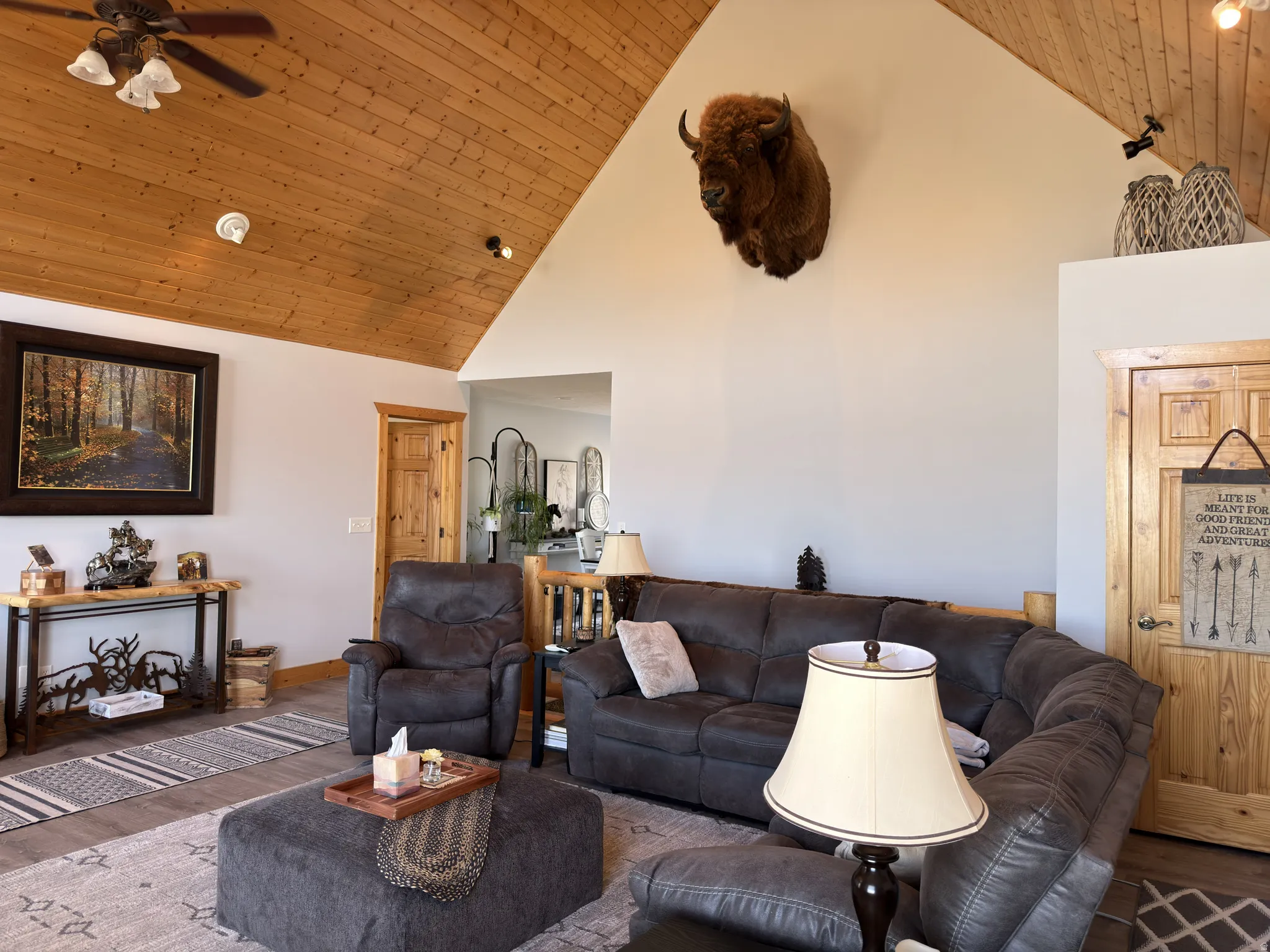 Vaulted tongue and groove wood ceiling featuring dual ceiling fans with integrated lighting.