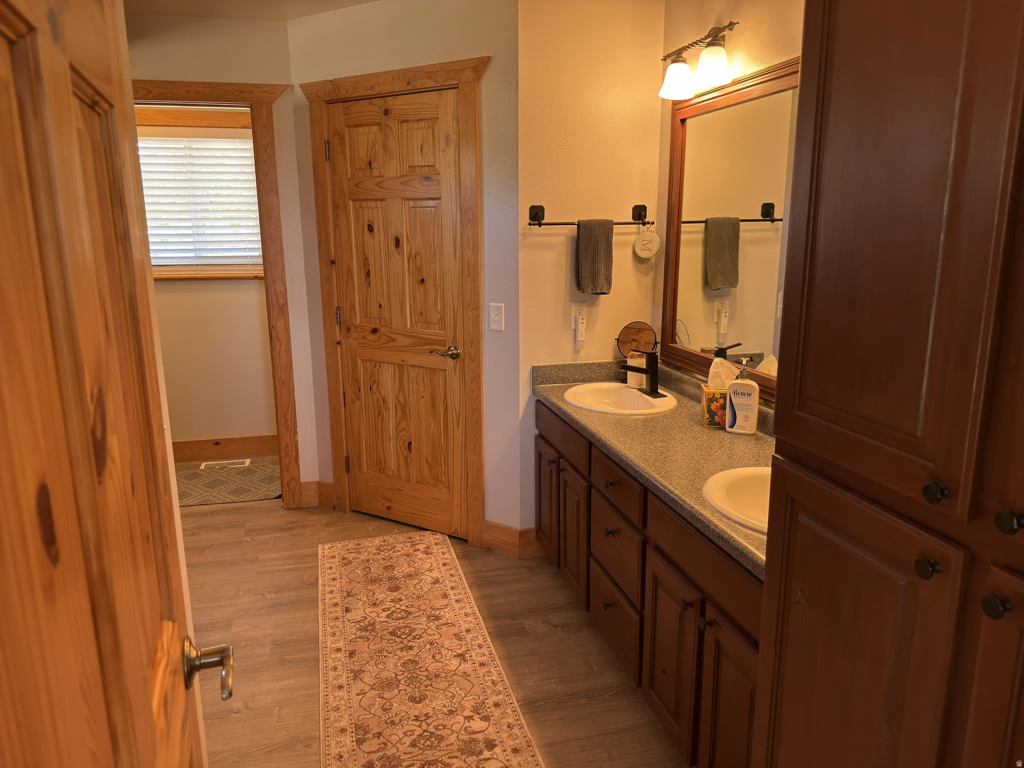 Double vanity with white oval sinks and dark faucets.