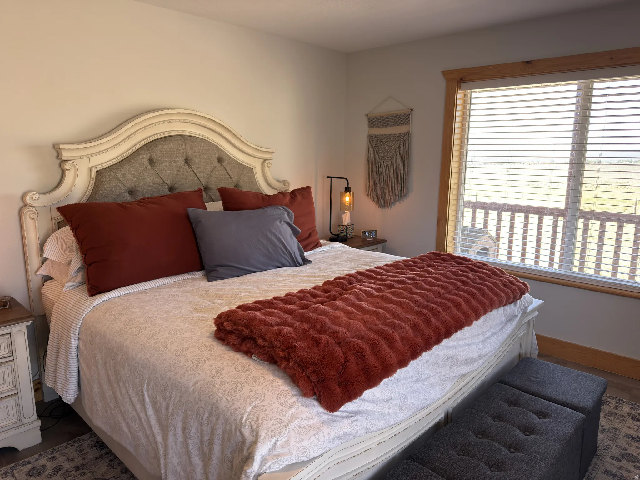 Bedroom featuring a large window with wood trim, offering expansive outdoor views