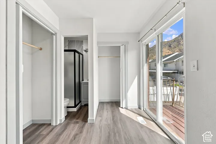 Master Bathroom with a Double Closet.Wood-finish flooring throughout, sliding glass doors to outdoor decking, and a bathroom with a shower enclosure