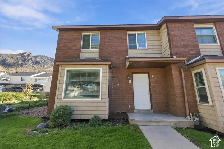 Brick and shingle siding exterior with a covered entry