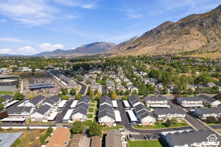 Residential buildings with dark roofs, covered parking structures, and mountain backdrop
