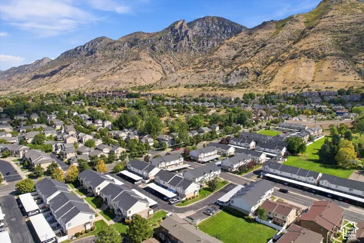 Expansive mountain backdrop with established residential development featuring mature landscaping, paved roadways, and covered parking structures