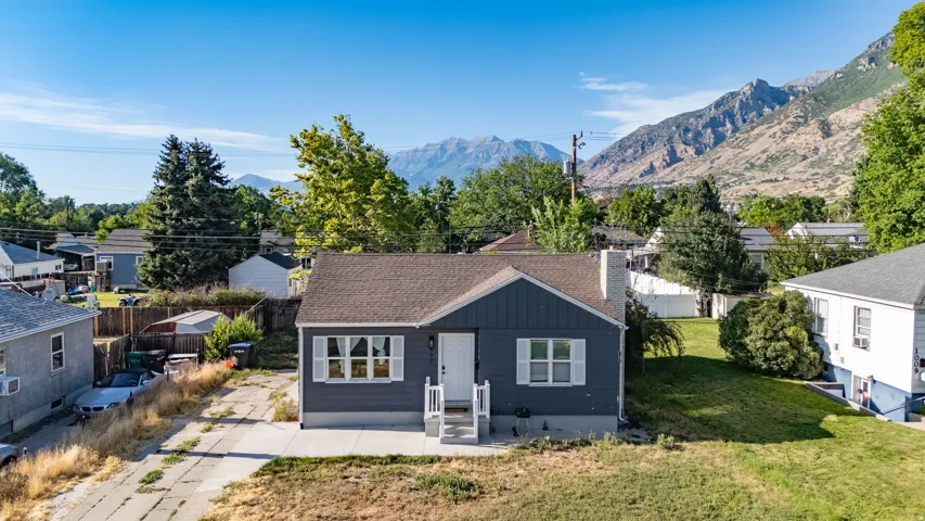 Ranch-style residence featuring a dark blue exterior, white trim, and a prominent front entrance with white railings