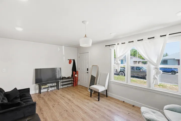 Bright living space featuring wood-finish flooring and white walls