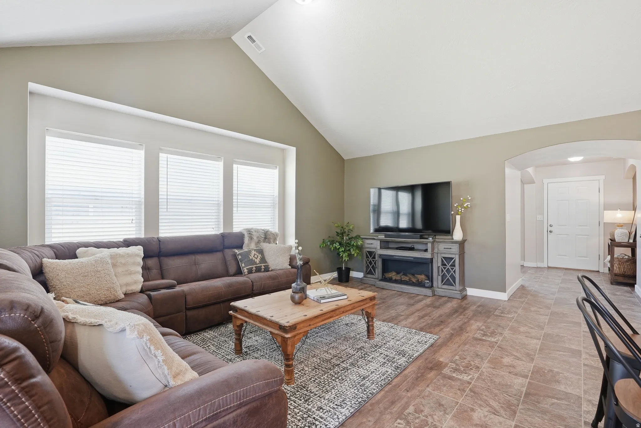 Vaulted ceiling living area featuring abundant natural light