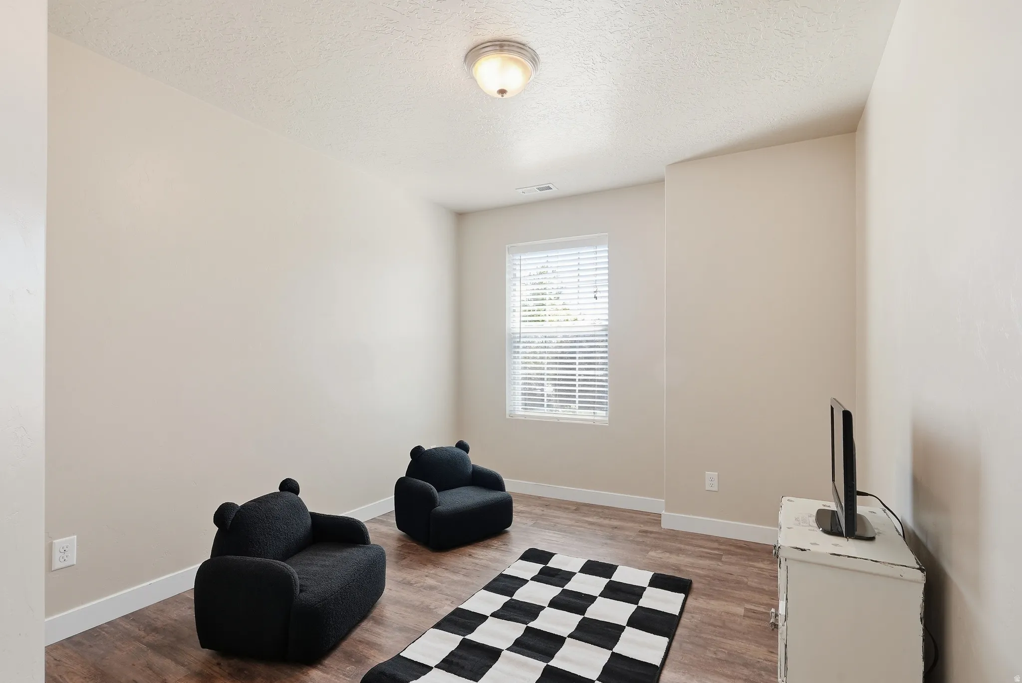 Neutral wall tones complement the wood-finish flooring