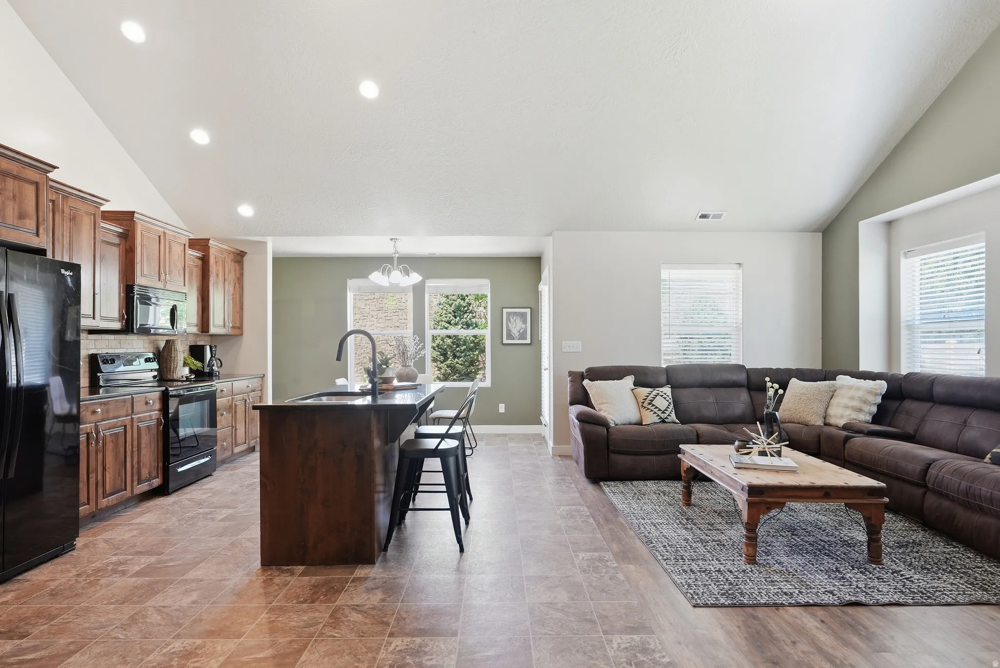 Open-concept living space featuring a vaulted ceiling and recessed lighting