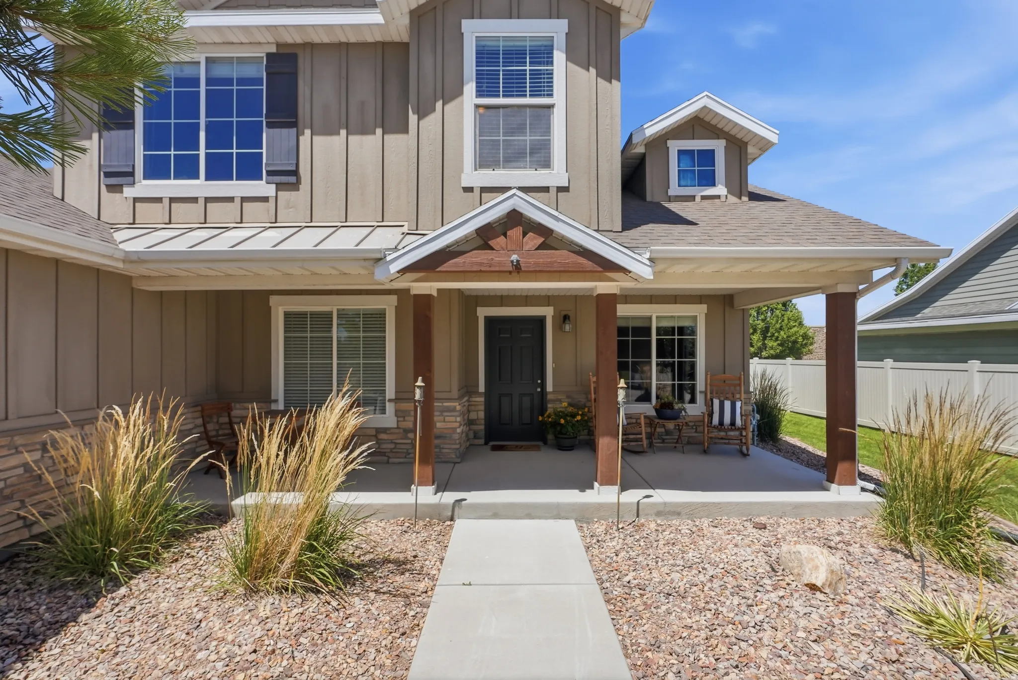 Covered front porch featuring stone accents and wood-finish columns