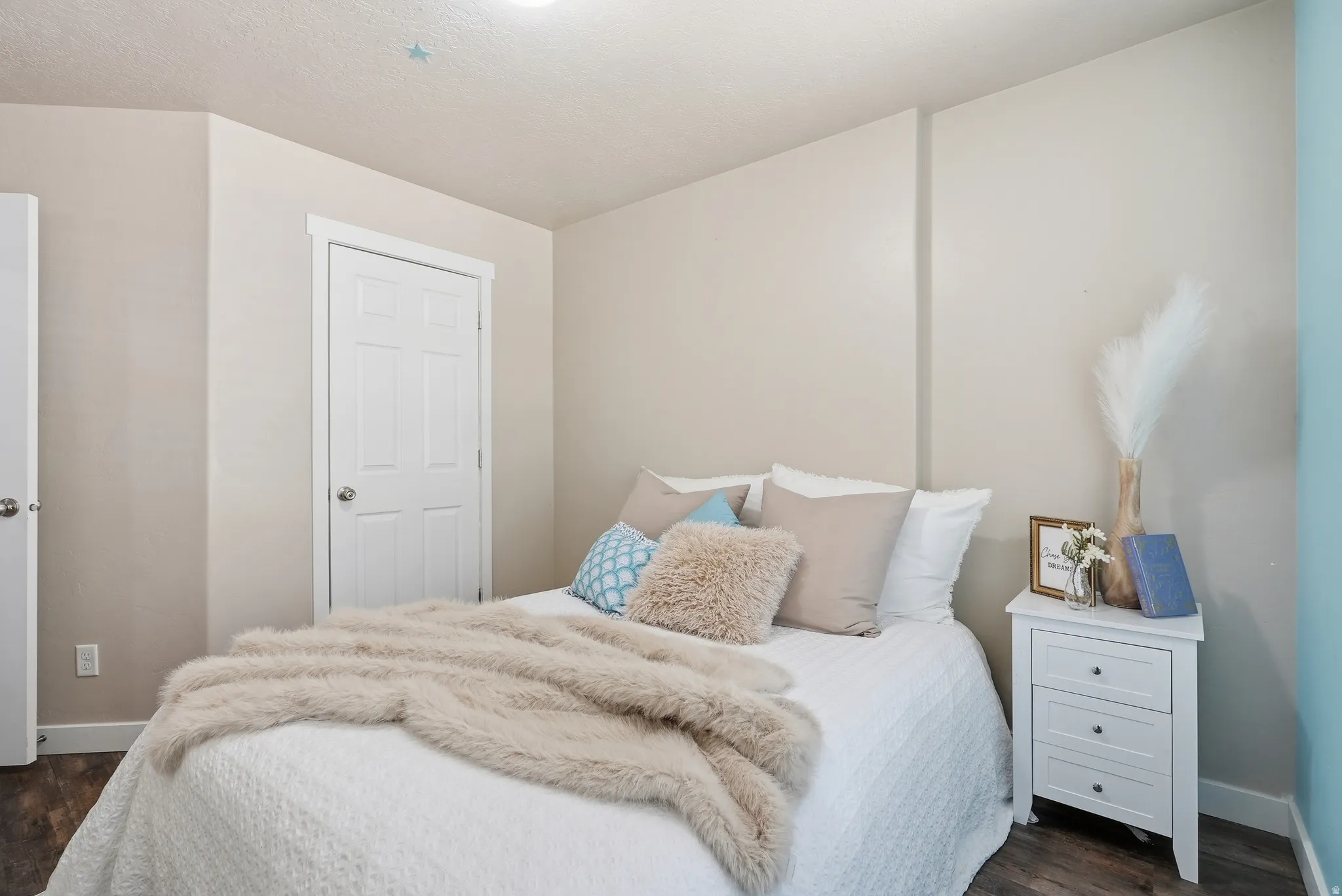 Bright room with wood-finish flooring, light neutral wall paint, and white trim molding