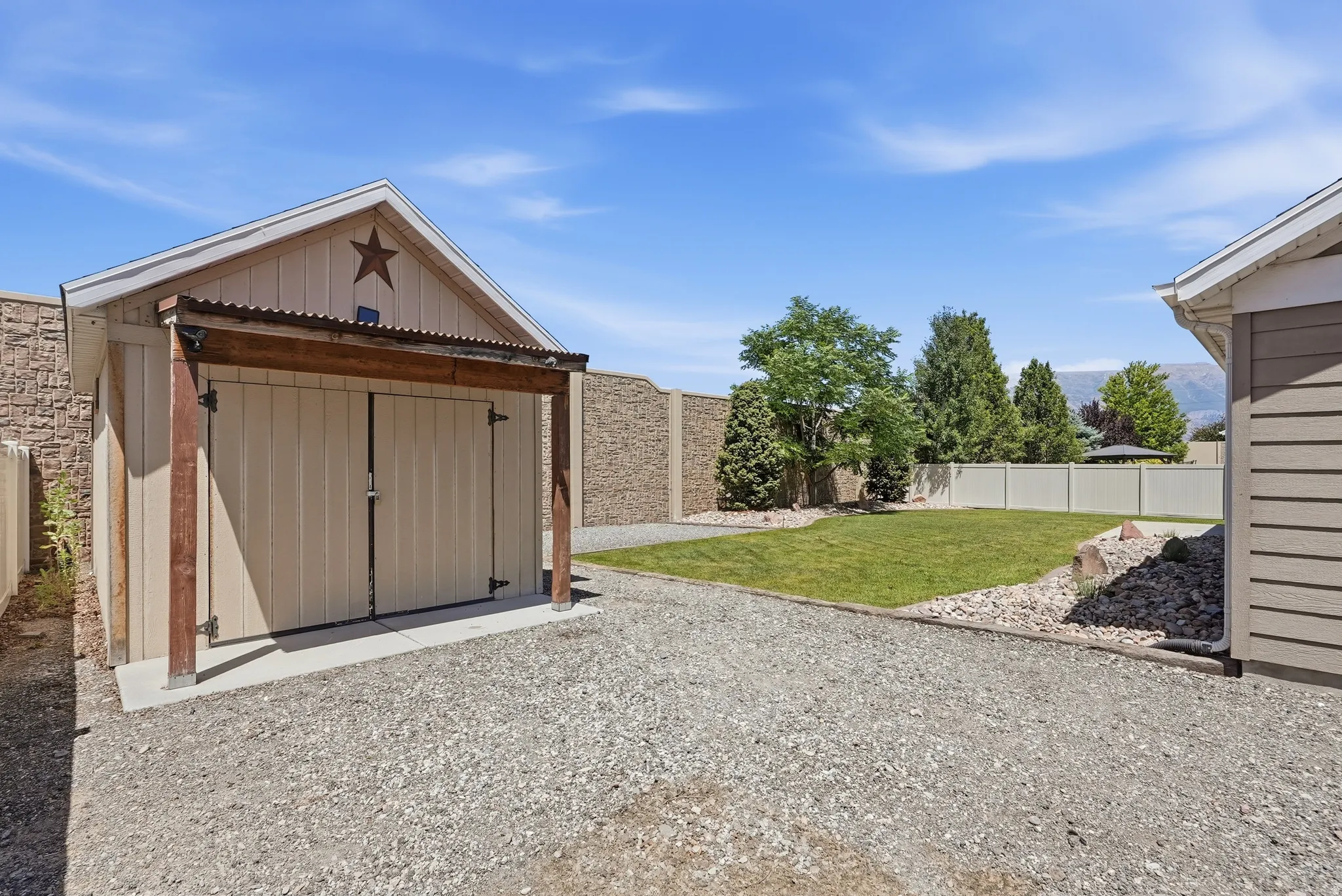 Detached garage with a metal roof accent, wood beam supports, and double doors