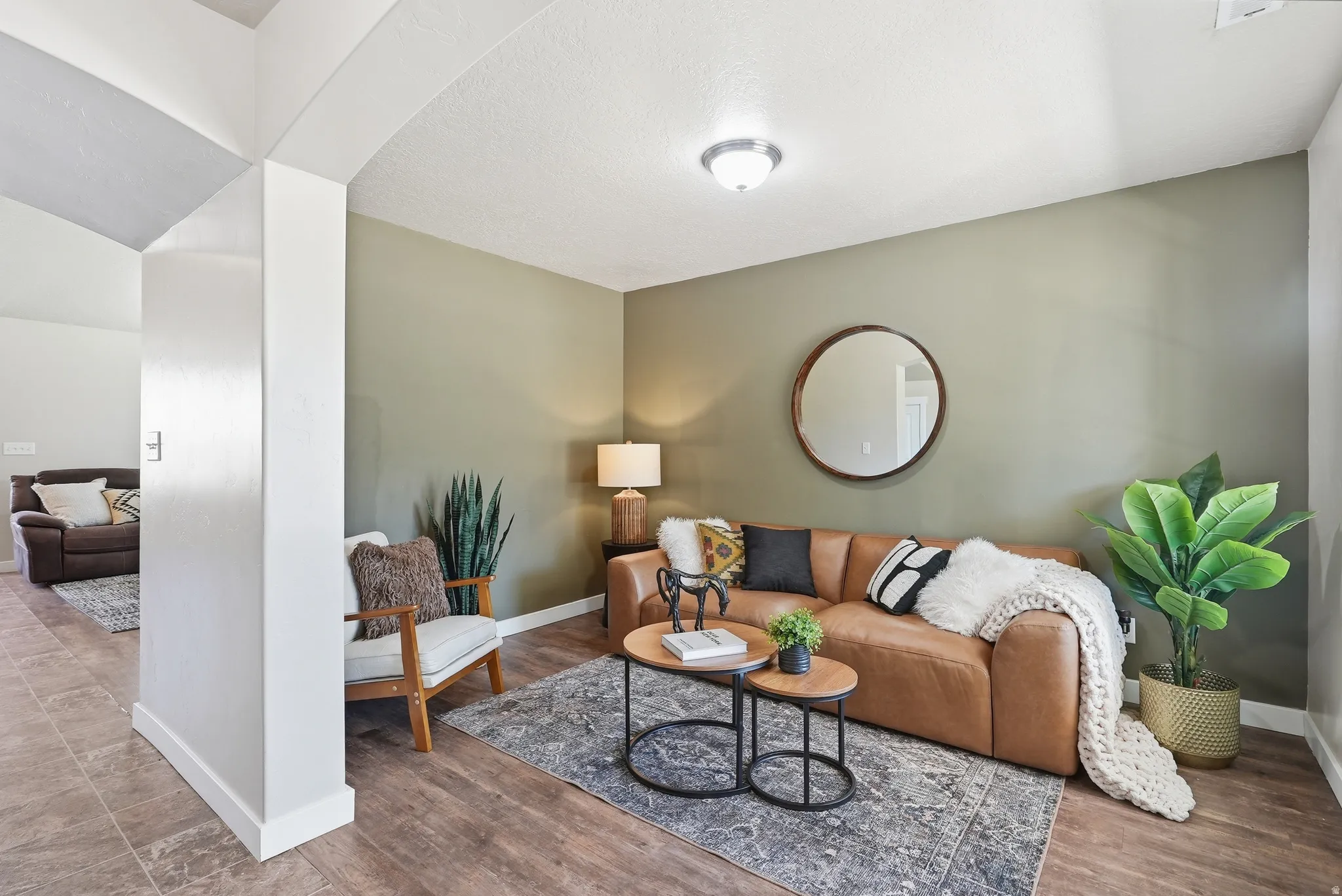 Open-concept living space featuring wood-finish flooring, recessed lighting, and a neutral wall color
