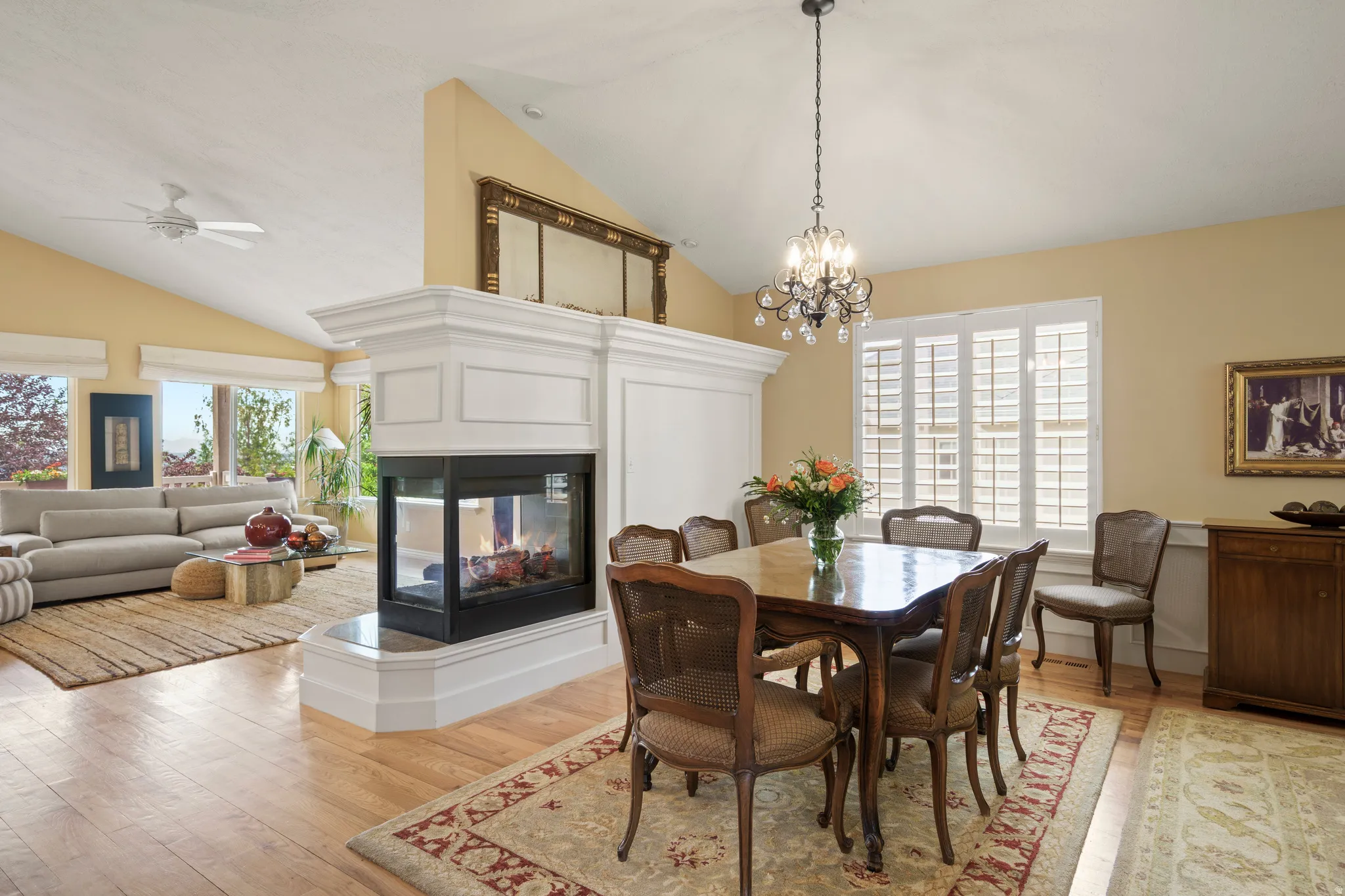 formal dining are a open-concept living area with vaulted ceilings and wood-finish flooring