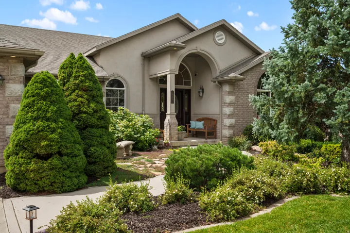 Stucco and brick exterior with arched entryway and covered porch