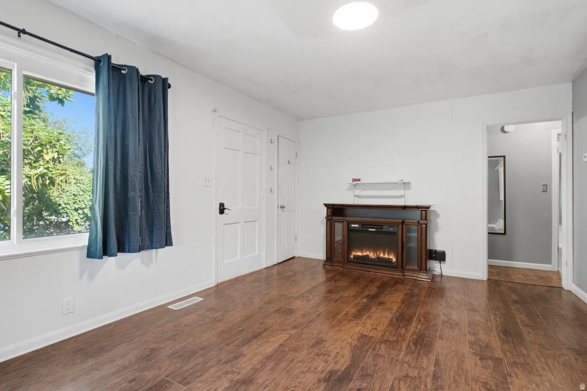 Wood-finish flooring, white paneled doors, and an electric fireplace feature in this living space