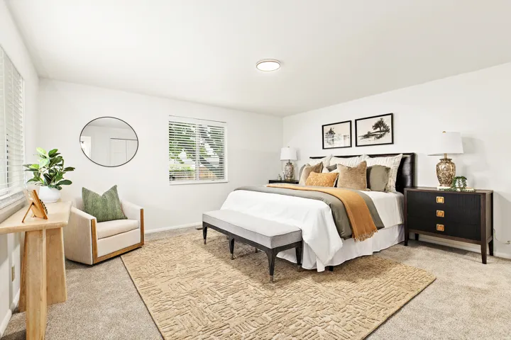 Carpeted bedroom featuring multiple windows with blinds, a built-in ceiling light, and white walls
