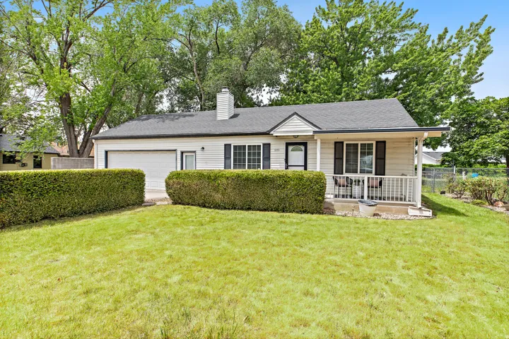 Single-story residence featuring white siding, a dark shingled roof, and a covered front porch