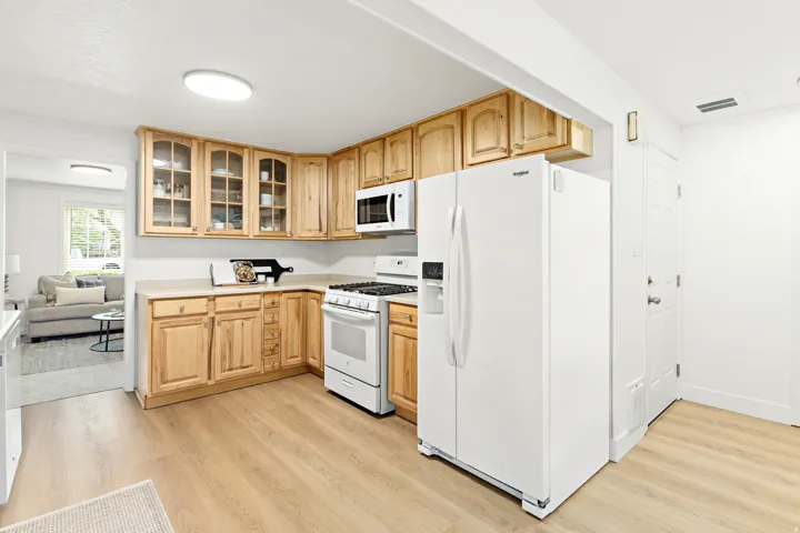 Kitchen featuring wood-finish cabinetry, light-toned countertops, and wood-finish flooring